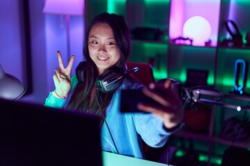 Poster - Young chinese woman streamer smiling confident make selfie by smartphone at gaming room