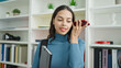 © Krakenimages.com - Young beautiful hispanic woman student listening voice message by smartphone holding folder at university classroom