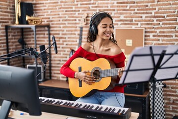 Canvas Print - Young african american woman musician playing classical guitar at music studio