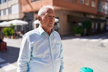 Canvas Print - Middle age grey-haired man looking to the side with serious expression at street