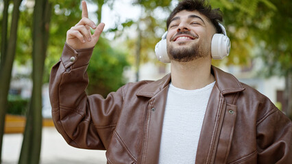 Sticker - Young arab man smiling confident listening to music and dancing at park