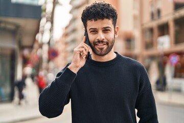 Sticker - Young arab man smiling confident talking on the smartphone at street