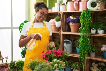 Sticker - African american woman florist using diffuser watering plant at flower shop