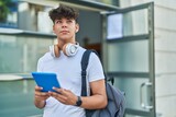 Young hispanic teenager student using touchpad with relaxed expression at university