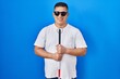 Hispanic young blind man holding cane smiling with a happy and cool smile on face. showing teeth.