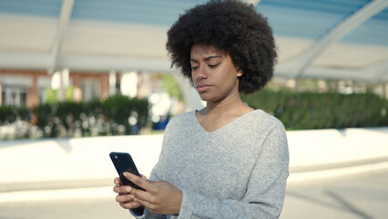 Poster - African american woman using smartphone with relaxed expression at park