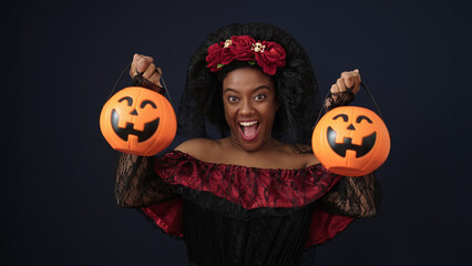 Sticker - African american woman wearing katrina costume holding halloween pumpkin baskets over isolated black background