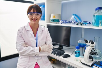 Poster - Young brunette woman working at scientist laboratory happy face smiling with crossed arms looking at the camera. positive person.