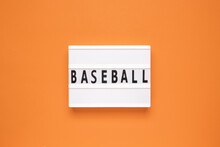 The Word Baseball On Lightbox Isolated Orange Background.