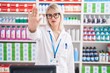 © Krakenimages.com - Young caucasian woman working at pharmacy drugstore doing stop sing with palm of the hand. warning expression with negative and serious gesture on the face.