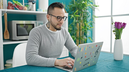 Poster - Hispanic man using laptop sitting on the table at dinning room