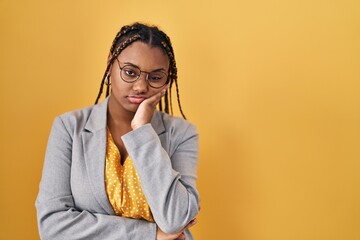 Sticker - African american woman with braids standing over yellow background thinking looking tired and bored with depression problems with crossed arms.