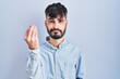 © Krakenimages.com - Young hispanic man with beard standing over blue background doing italian gesture with hand and fingers confident expression