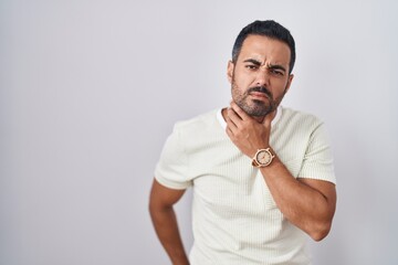 Canvas Print - Hispanic man with beard standing over isolated background touching painful neck, sore throat for flu, clod and infection