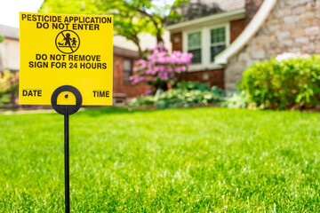 Pesticide application sign on front yard of suburban home