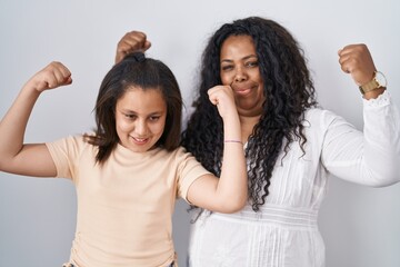 Poster - Mother and young daughter standing over white background showing arms muscles smiling proud. fitness concept.