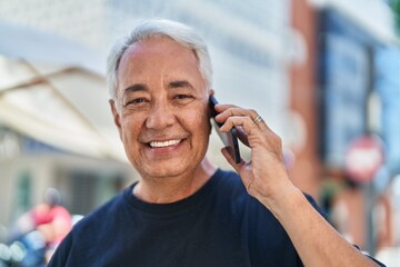 Poster - Middle age grey-haired man smiling confident talking on the smartphone at street