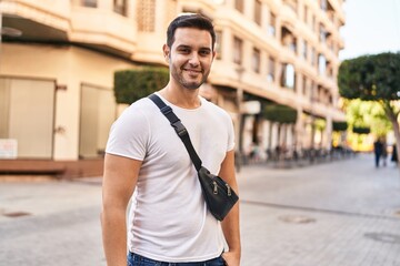 Wall Mural - Young hispanic man smiling confident standing at street