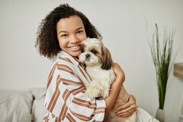 Wall Mural - Candid waist up portrait of black young woman holding cute dog and smiling at camera at home