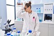© Krakenimages.com - Young woman working at scientist laboratory surprised with hand on head for mistake, remember error. forgot, bad memory concept.