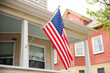 US flag proudly displayed in front of an American house symbolizes patriotism, national identity, and love for one's country. It represents unity, freedom, and the values upon which the United States 