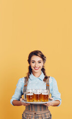 Wall Mural - Oktoberfest Tradition. Waitress wearing traditional clothes and holding beers at the festival isolated on yellow background with space to text. copy space. German culture concept. AI Generative	