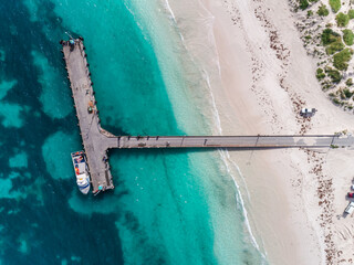 Wall Mural - Aerial view of sandy beach with waves and fishing jetty in Lancelin, Western Australia. Sunny day in summer with tropical blue water. Top view. Coastal, Seascape. Aerial view beautiful tropical