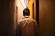 back view of a man walking down a narrow alleyway