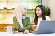 © DG PhotoStock - Happy cheerful Asian females university student discussing or doing a homework together in the pantry area in dormitory.