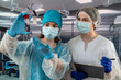 © RomanR - Two hospital employees  female surgeon and nurse are standing with crossed arms in  hospital.
