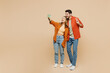 © ViDi Studio - Full body young couple two friends family man woman wear casual clothes together do selfie shot on mobile cell phone post photo on social network isolated on pastel plain light beige color background.