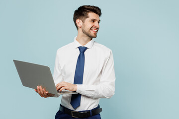 Young employee IT business man corporate lawyer wears classic formal shirt tie work in office hold use laptop pc computer look aside on area isolated on plain pastel blue background studio portrait.