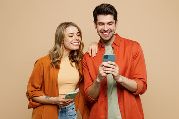 young smiling happy couple two friends family man woman wear casual clothes hold in hand use mobile 