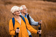 © Zoran Zeremski - Active senior couple with backpacks hiking together in nature on autumn day.