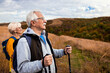 © Zoran Zeremski - Active senior couple with backpacks hiking together in nature on autumn day.