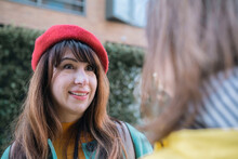 Happy Woman Wearing Red Beret Talking With Friend