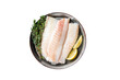 Fresh raw cod fish fillets with herbs served on steel tray.  Isolated, transparent background.