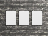 Fototapeta Tematy - Three Blank vertical poster hanging with clips on a wall Mockup. 3D rendrering
