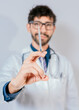 © IHERPHOTO - Close up of doctor holding a syringe isolated. Smiling doctor holding a syringe on isolated background