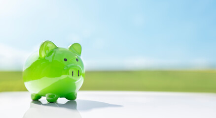 green piggy bank against blue sky background savings, accounting, banking and business account or su