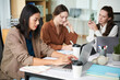 © DragonImages - Team of businesswomen working on big project at office table