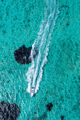 Wall Mural - Aerial view of fast boat on turquoise sea on a sunny day. Fast yacht on the ocean. Seascape from a drone. Seascape from the air. Vibrant bright sunny day in summer wallpaper. Coastal Seascape