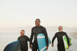 © KOTO - Older surfers carrying boards on beach
