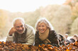 © KOTO - Older couple laying in autumn leaves