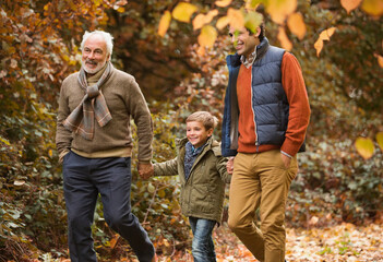 Three generations of men walking in park