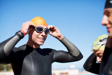 Wall Mural - Triathlete adjusting goggles outdoors