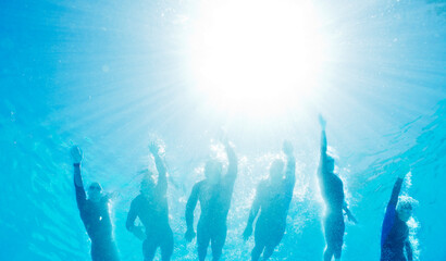 Canvas Print - Triathletes in wetsuits underwater