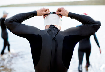 Wall Mural - Triathlete adjusting goggles at start of race