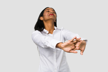 Wall Mural - Young Indian woman cut out isolated on white background stretching arms, relaxed position.