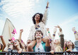 © KOTO - Cheering woman on man shoulders at music festival